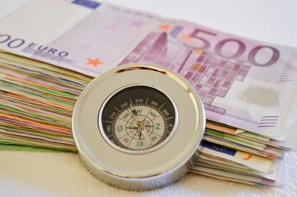 Geldscheine mit eine Kompass davor